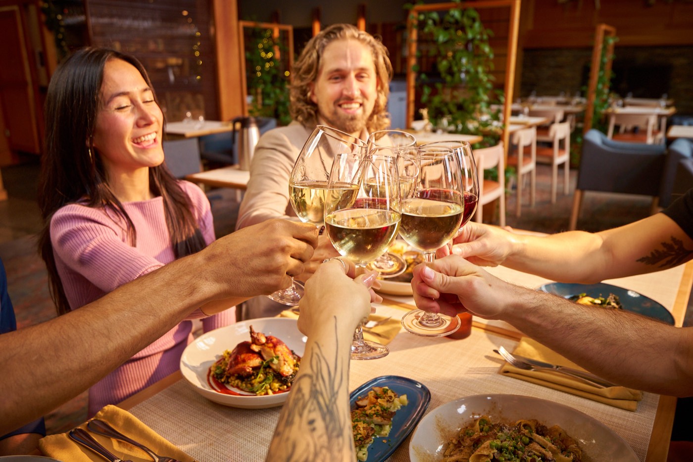 Friends raising wine glasses over dinner in the restaurant
