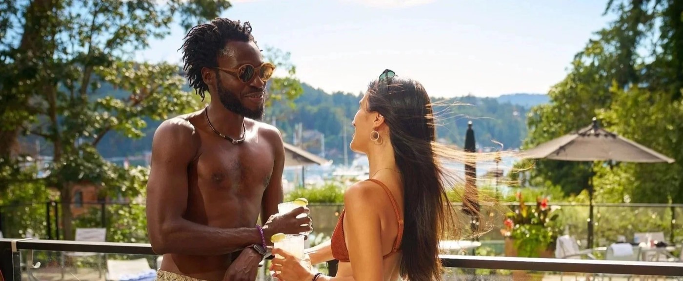A couple with cocktails on the pool deck above the marina