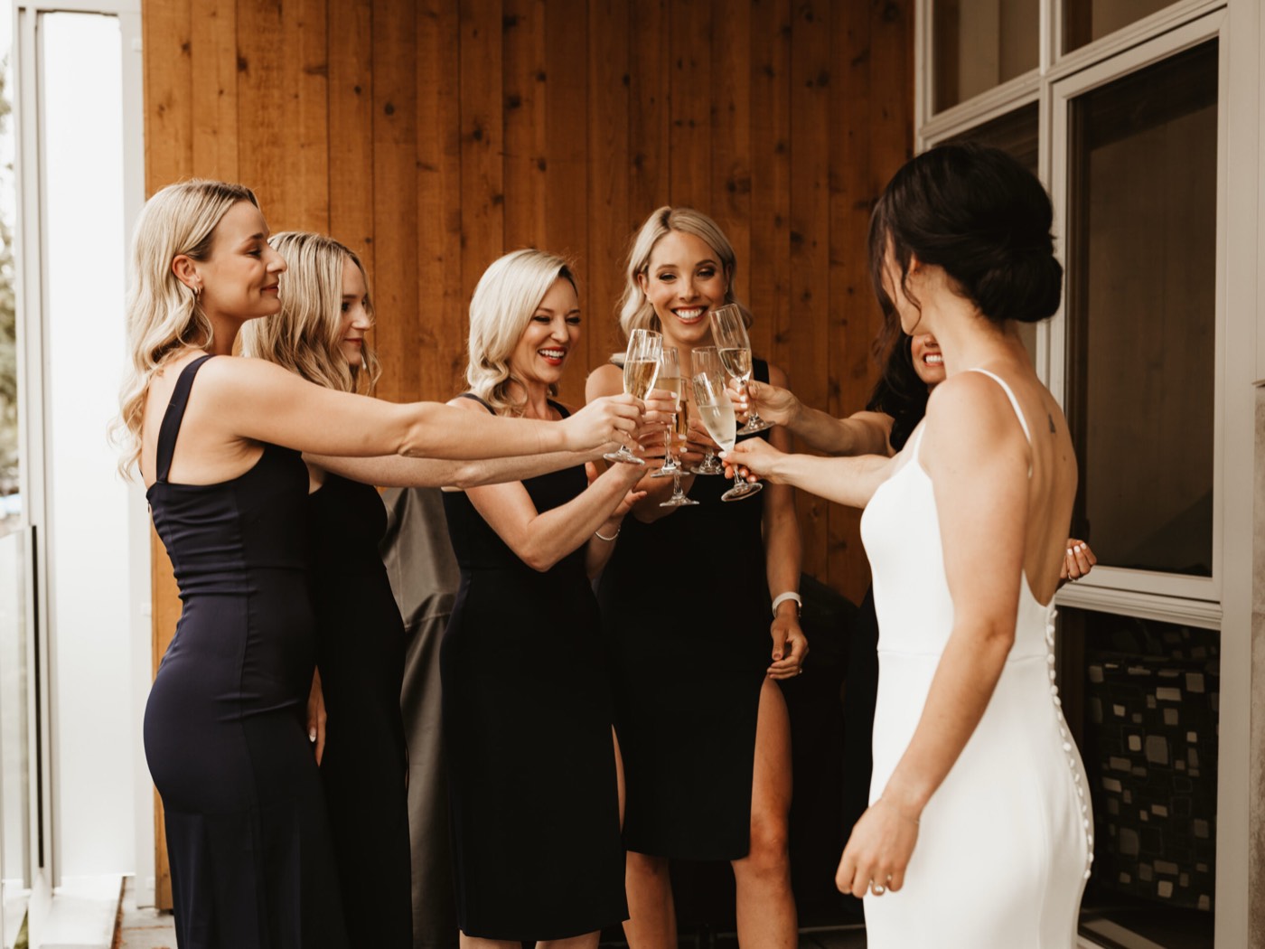 A bride and her party raising champagne glasses